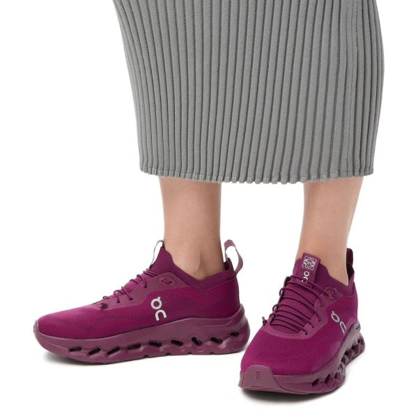 Person wearing magenta running shoes with a gray ribbed midi skirt, visible ankles.