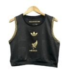3e9e470b-0757-4f3e-b22d-b12062d7c02e | UAE SPORT STORE Product photo: black sleeveless crop top with gold trim on the armholes and gold México emblems on the front (including the eagle crest and 'MÉXICO' text).