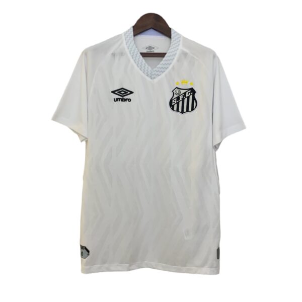 White soccer jersey on a hanger, featuring a blue-patterned collar, Umbro logo on the left chest, and a black-and-white shield crest with three yellow stars above it.
