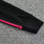 Coldsleeve: black athletic sleeve with a pink stripe along the side, resting on a gray carpeted floor.