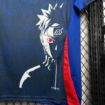 Close-up of blue fabric with a white graphic logo and a red stripe, draped over a chain-link fence on a black metal rack edge.
