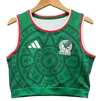 Green Mexico training jersey with Adidas logo and national crest, sleeveless crop top with red/white trim and circular pattern.