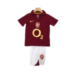 405bfa7f-Photoroom.png-Photoroom | UAE SPORT STORE Maroon Arsenal football jersey with gold O2 logo on a hanger, paired with white shorts featuring the club crest.