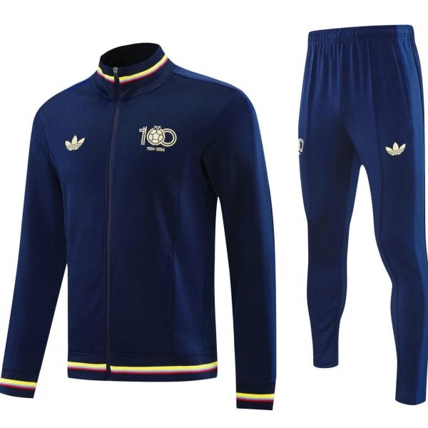Navy blue zip-up track jacket with rainbow striped collar and cuffs, featuring a crest and '1924-2024' mark; matching navy pants with side stripe.