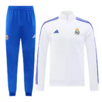 White Real Madrid training jacket with blue stripes and crest, paired with blue track pants featuring the club badge.