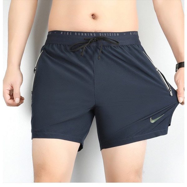 Navy men's athletic shorts with a drawstring waist and zippered pockets, featuring a small Nike swoosh on the left leg.