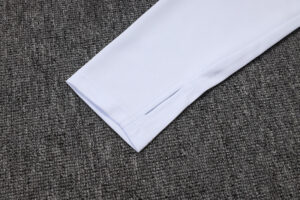 White shirt sleeve cuff extended on a dark gray carpet.