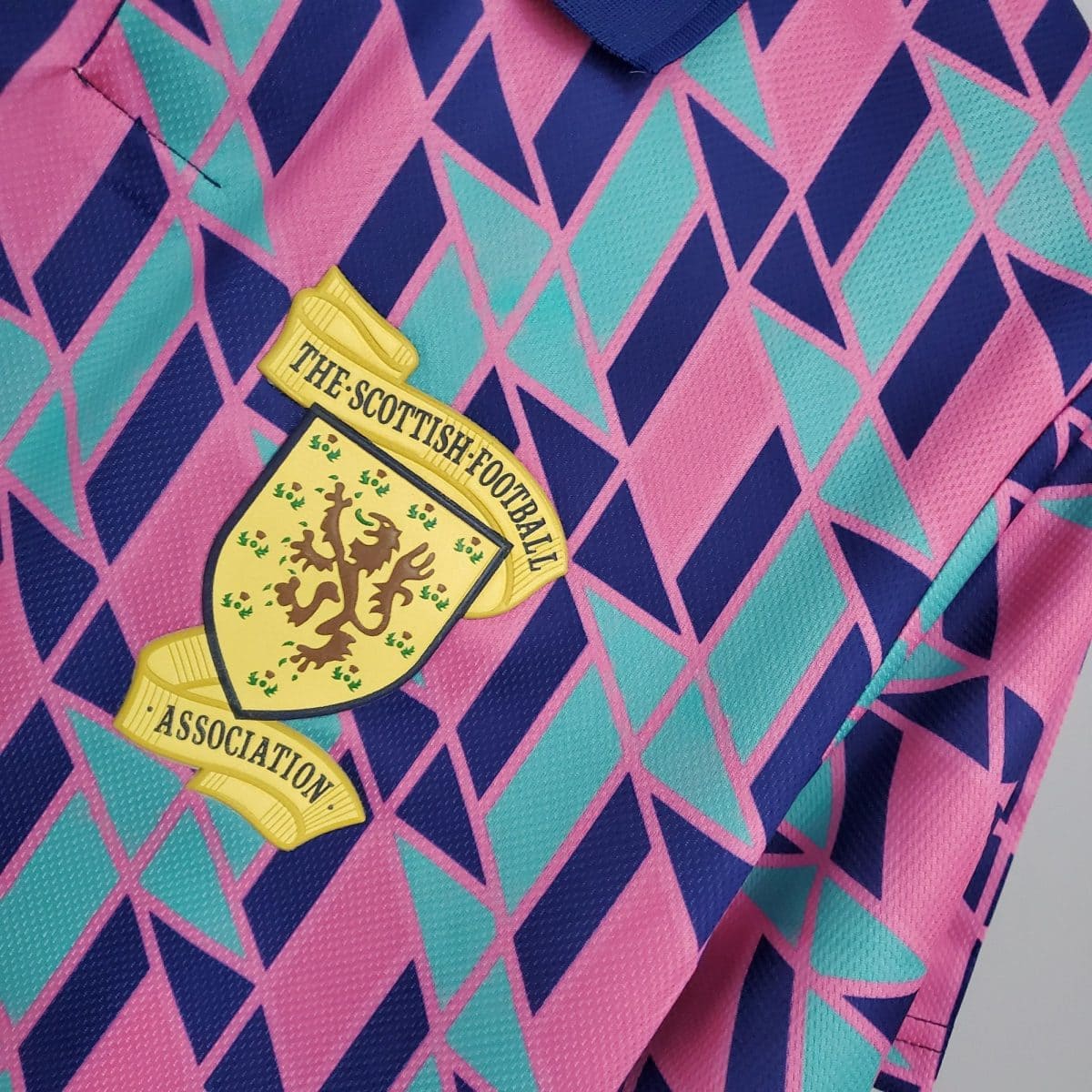 Close-up of pink, teal, and navy geometric fabric with a yellow Scottish Football Association badge partially visible.