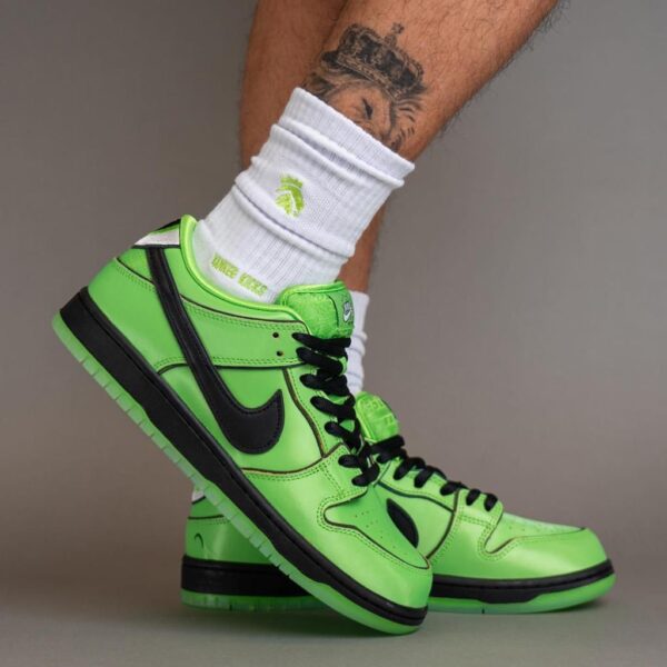 Bright green Nike high-top sneakers with black swoosh worn with white socks; tattooed leg visible above the shoe.