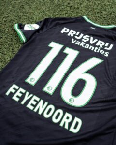 451967840_883743737121683_4424140167580152528_n | UAE SPORT STORE Black soccer jersey with green and white trim spread on grass, showing a large white outlined number 16 and the word 'VAKANTIES'.