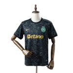 Black patterned soccer jersey on a mannequin with Betano sponsor and Sporting CP crest on the chest, short sleeves and gold logo detail.