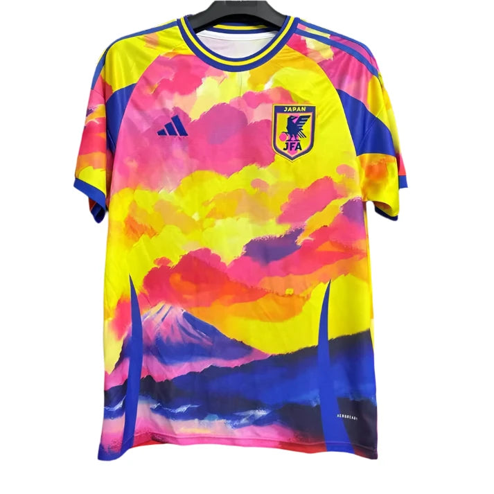 4711AD2C-E3B4-4FA0-A01E-C2025DC29CE5 | UAE SPORT STORE Colorful Japan soccer jersey with pink, yellow, and blue cloud/landscape design on a hanger; features JFA crest and Adidas logo.