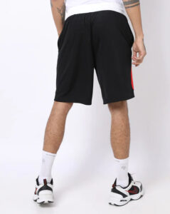 Back view of a person wearing black athletic shorts, white socks, and black-and-white sneakers.