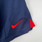 477dfa63_5b95f9f0-ae1e-4987-9bd7-0d9dd893a887 | UAE SPORT STORE Close-up of dark blue fabric with a red Nike swoosh stitched along a seam nearby.