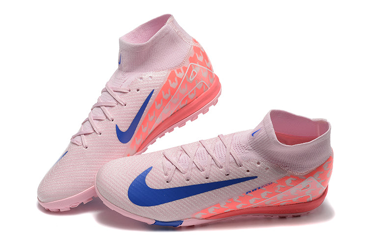 47ce5495 | UAE SPORT STORE Pink Nike turf soccer shoes with blue swoosh and geometric gradient on heel, lace-up mid-cut.