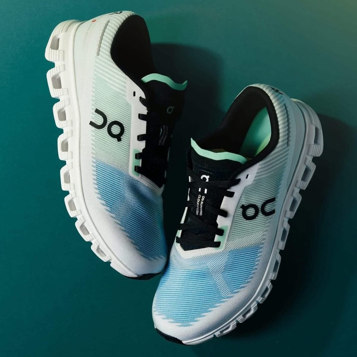 White and light blue running shoes with chunky white soles on a teal background.