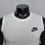 Close-up of a white Nike sleeveless shirt on a glossy black mannequin torso, with the Nike swoosh logo visible on the right chest area.