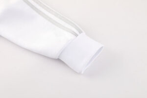 Close-up of a white athletic sleeve cuff with a ribbed cuff and a slim silver seam along the arm partitioned detail