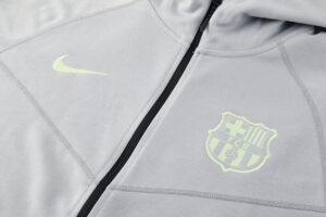 Gray zip-up athletic jacket with neon Nike swoosh and FC Barcelona crest on the chest area.