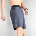 Man wearing gray Nike athletic shorts with a black waistband, zipper pocket, and drawstring at the waist; mid-thigh length, athletic gear.