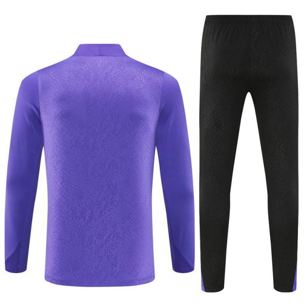 Purple long-sleeve athletic top with a textured pattern paired with black textured athletic pants.