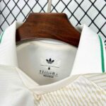 White polo shirt on a wooden hanger; Adidas logo on the inner label shows size M and 'Made in Thailand'.
