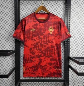 Red Portugal national team jersey hanging on a wooden hanger against a metal grid backdrop, showing crest on the chest area.