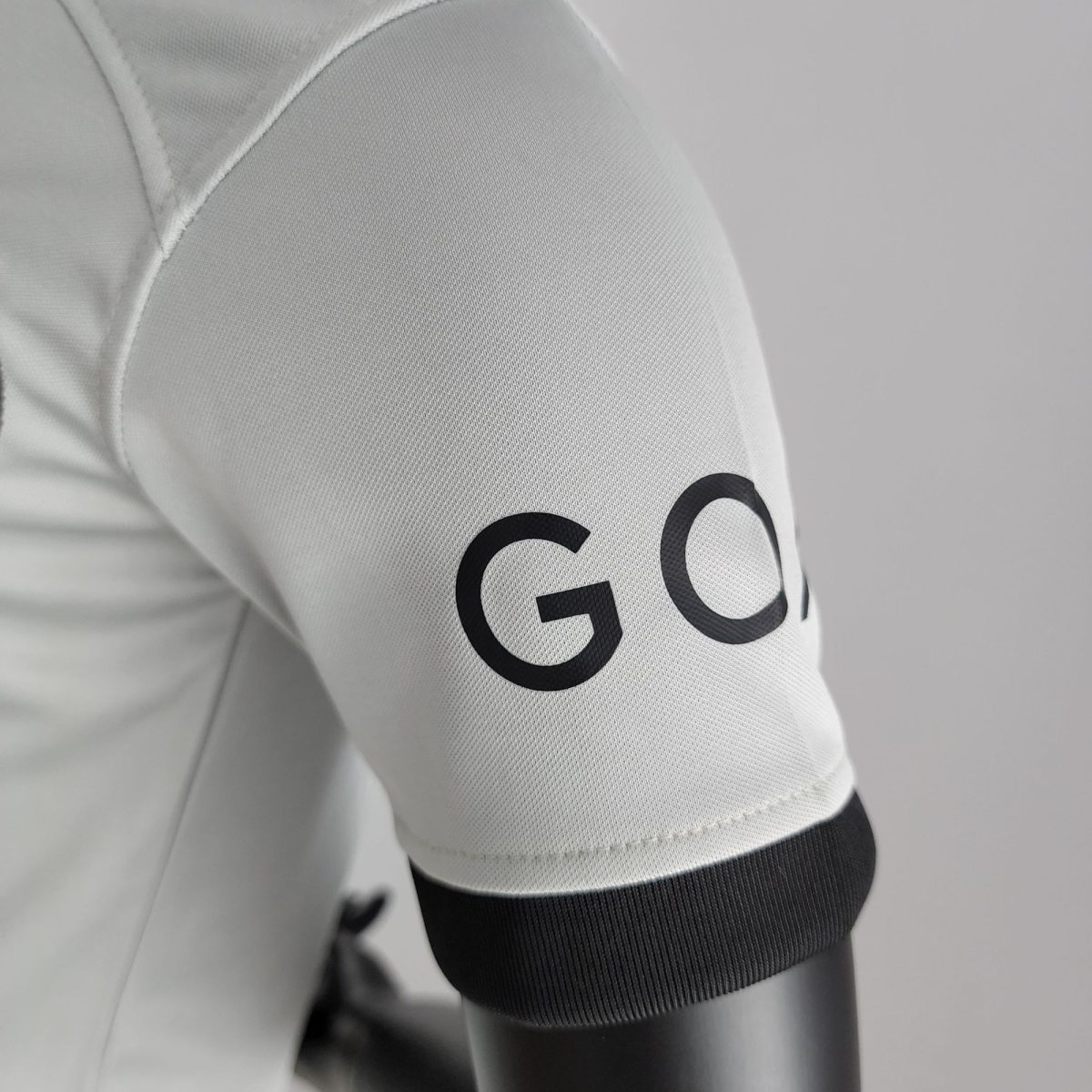 Close-up of white fabric with a visible seam and a bold black curved graphic edge.