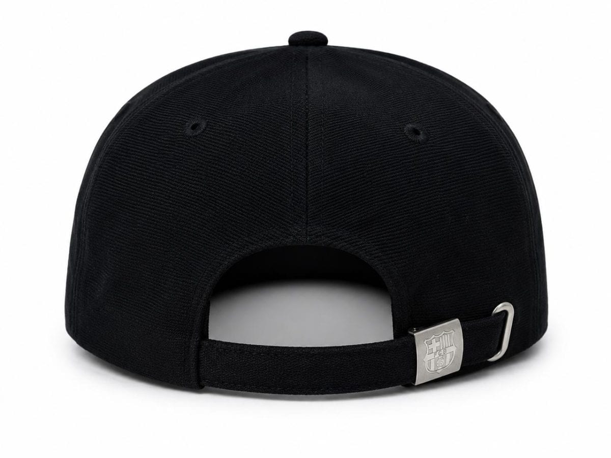 Black baseball cap viewed from the back with an adjustable strap and silver buckle with a crest.