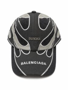 Black and dark gray Balenciaga baseball cap with white embroidered flame-like seams and the BALENCIAGA logo on the crown.