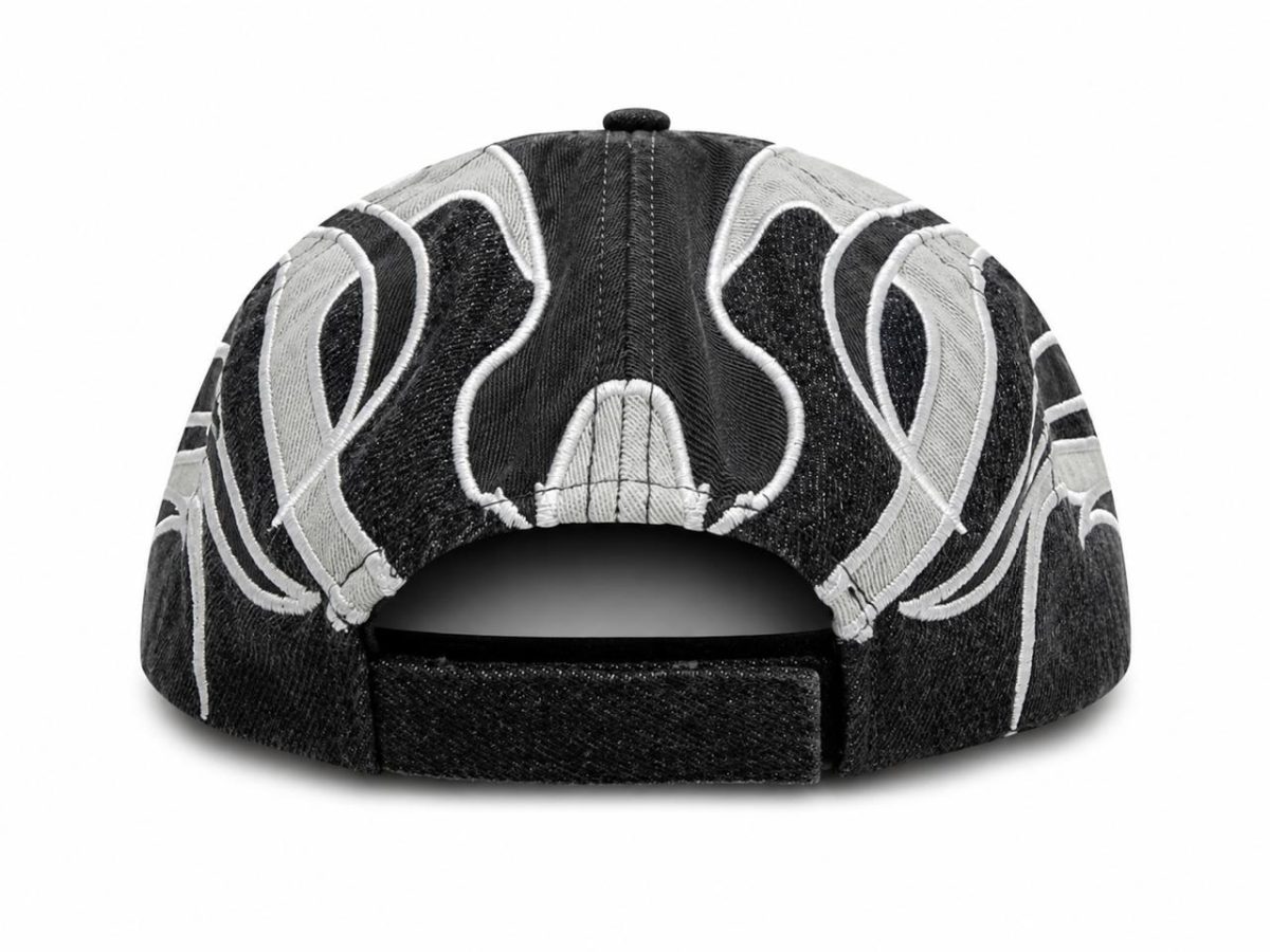 Back view of a black denim cap with a white embroidered swirl pattern and an adjustable strap