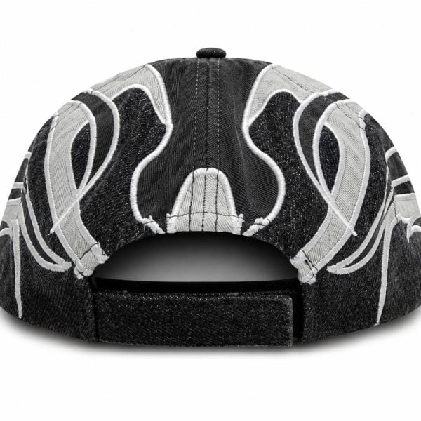 Back view of a black denim cap with a white embroidered swirl pattern and an adjustable strap