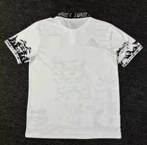 Back view of a white T-shirt with black patterned collar and sleeve graphics; faint large design on the back remains visible.