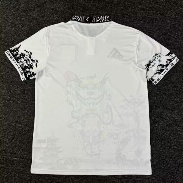 Back view of a white T-shirt with black patterned collar and sleeve graphics; faint large design on the back remains visible.