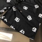 Black drawstring shorts with a repeating white interlocking-C logo pattern all over the fabric, showing visible stitching at the hem and drawstring ends.