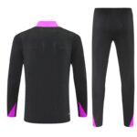 Back view of a black athletic long-sleeve top with pink collar and pink cuffs, paired with matching black jogger pants with pink accents.