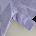 Close-up of lavender necktie fabrics with a dotted pattern and visible stitching along seams, highlighting textured weave.