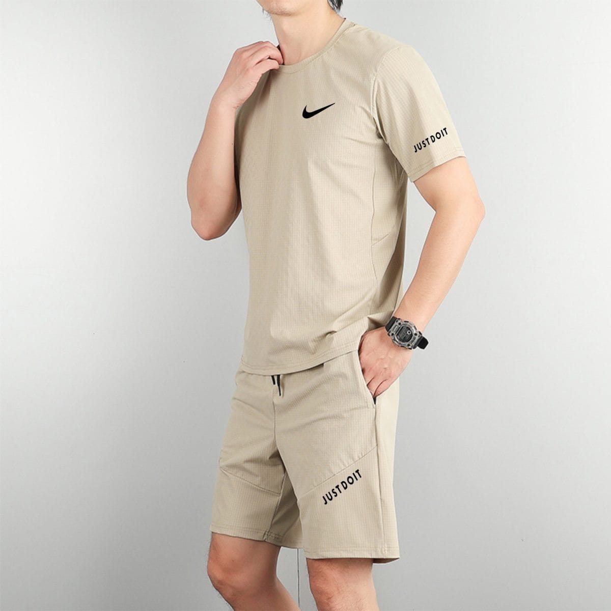 Person in beige athletic shirt and shorts, with a black Nike swoosh on the chest and 'JUST DO IT' on the leg area.
