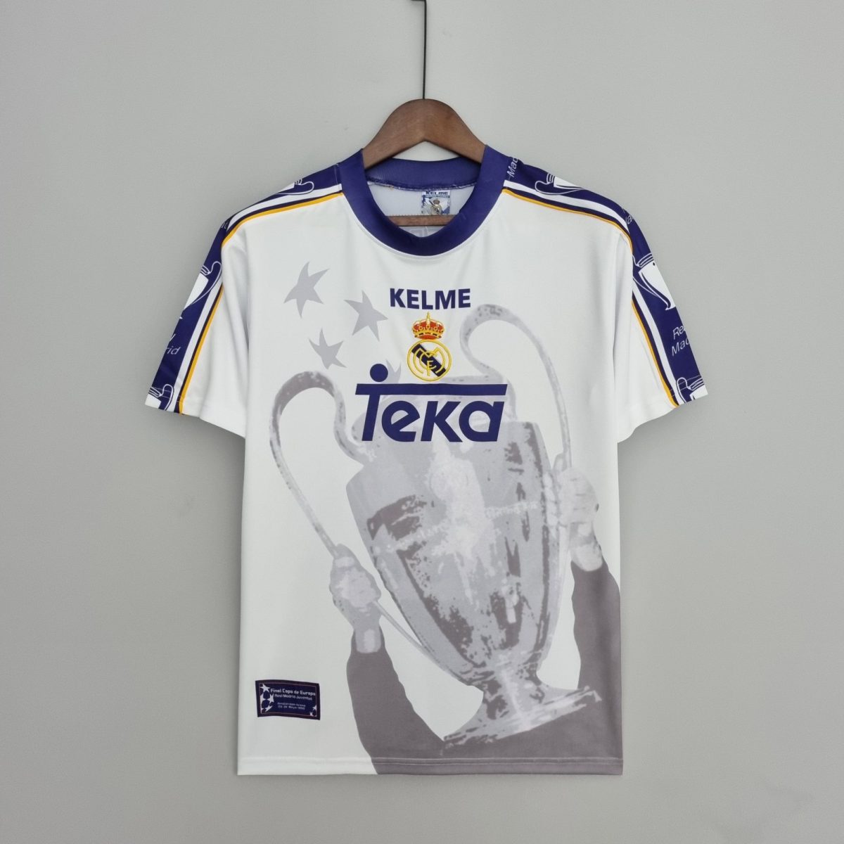 White Real Madrid sports jersey on a wooden hanger, centered on a gray background, featuring TEKA sponsor and crest.