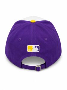 Rear view of a purple baseball cap with an adjustable strap and yellow top button, featuring an embroidered MLB logo patch on the back panel.
