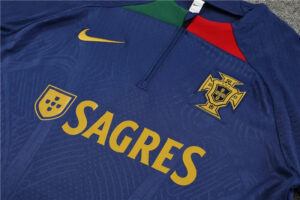 Portugal national team blue jersey with gold SAGRES sponsor, crest, and Nike swoosh shown on the chest.