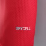 Close-up of red fabric with white text reading 'DRYCELL' near the lower edge, showing a soft, textured surface.