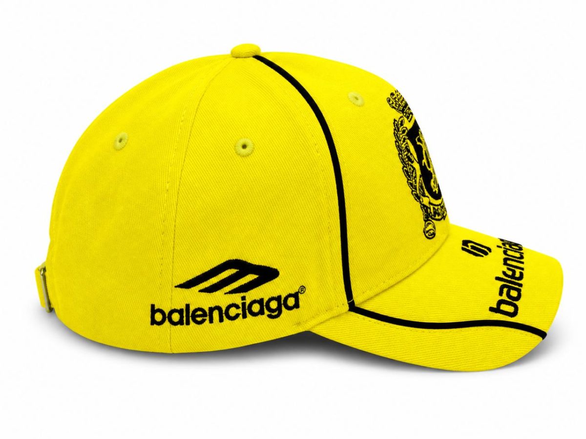 Bright yellow Balenciaga baseball cap with black embroidered logo and curved brim visible from the side edge.