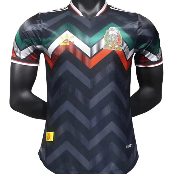 Navy football jersey with a bold zigzag chevron pattern in black and gray, green and red accents, crest on the left chest, and a white with red-trim collar on a mannequin.