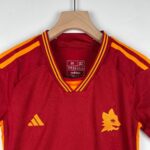 Red Adidas sports jacket on a wooden hanger with orange and yellow shoulder stripes.