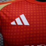 Close-up of a red athletic jersey fabric with a white Adidas logo.