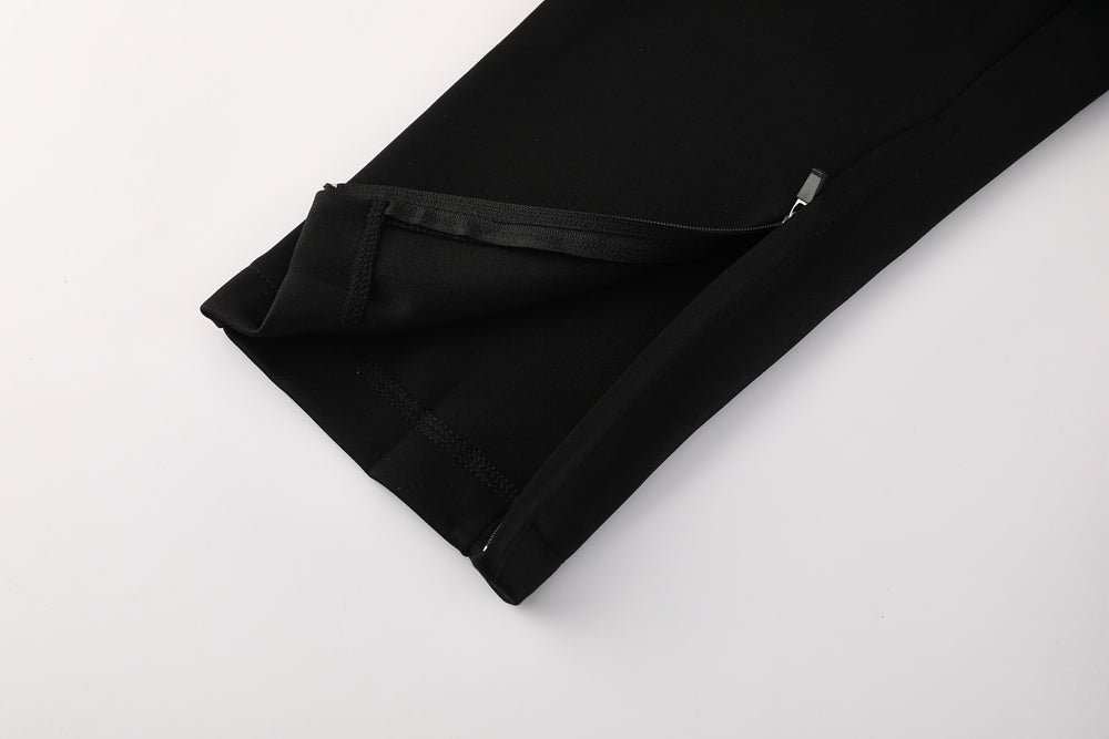 4f322f8d | UAE SPORT STORE Close-up of a black jogger/leggings pant leg with an ankle zipper and cuff detail on a light background.