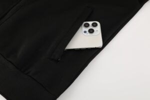 4f98fbd2 | UAE SPORT STORE White iPhone with a triple-camera module nestled in the pocket of a black bag/backpack.