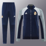 5040440a | UAE SPORT STORE Real Madrid training tracksuit: navy jacket with light gray sleeves, white stripes, and crest paired with matching navy pants featuring the club logo.