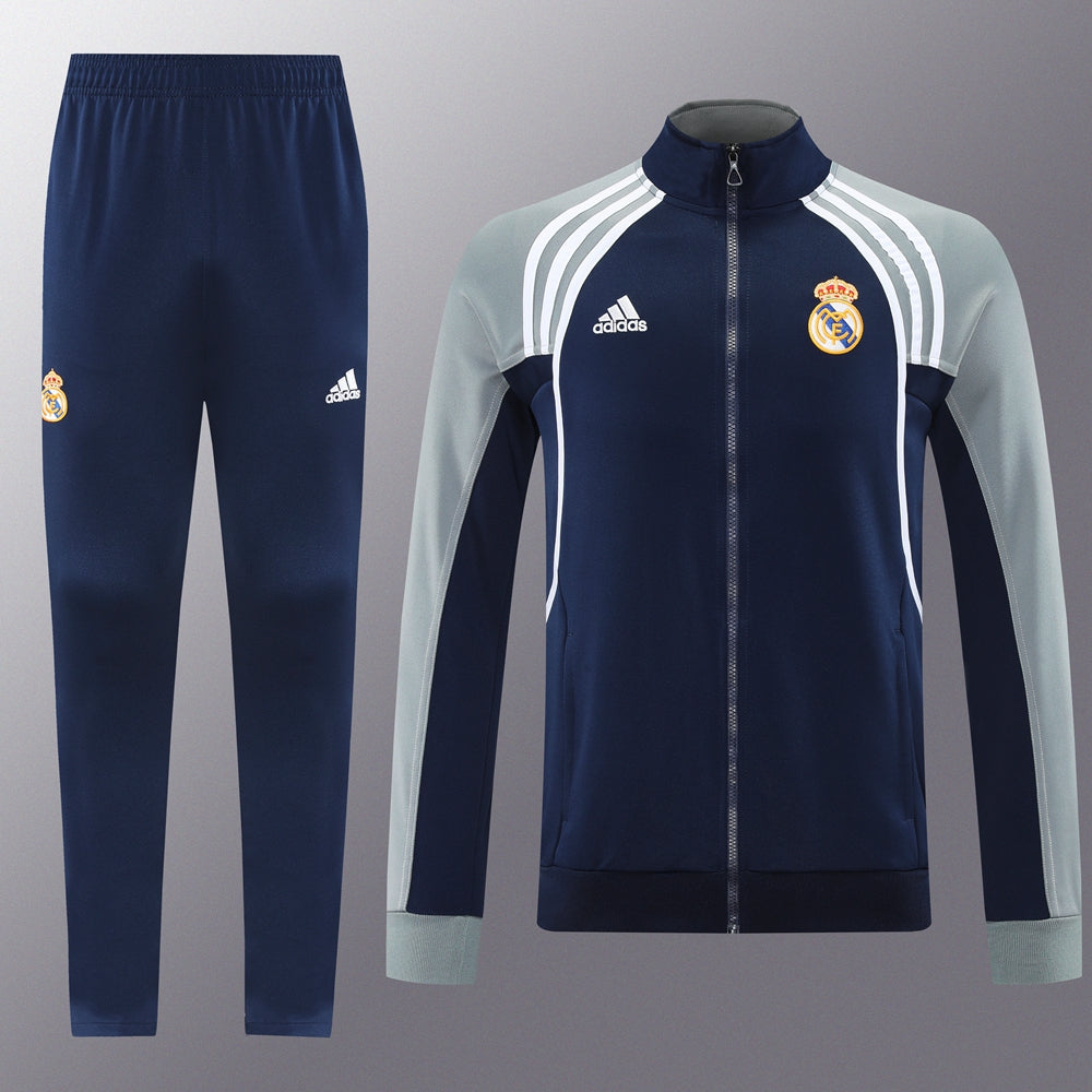 5040440a | UAE SPORT STORE Real Madrid training tracksuit: navy jacket with light gray sleeves, white stripes, and crest paired with matching navy pants featuring the club logo.